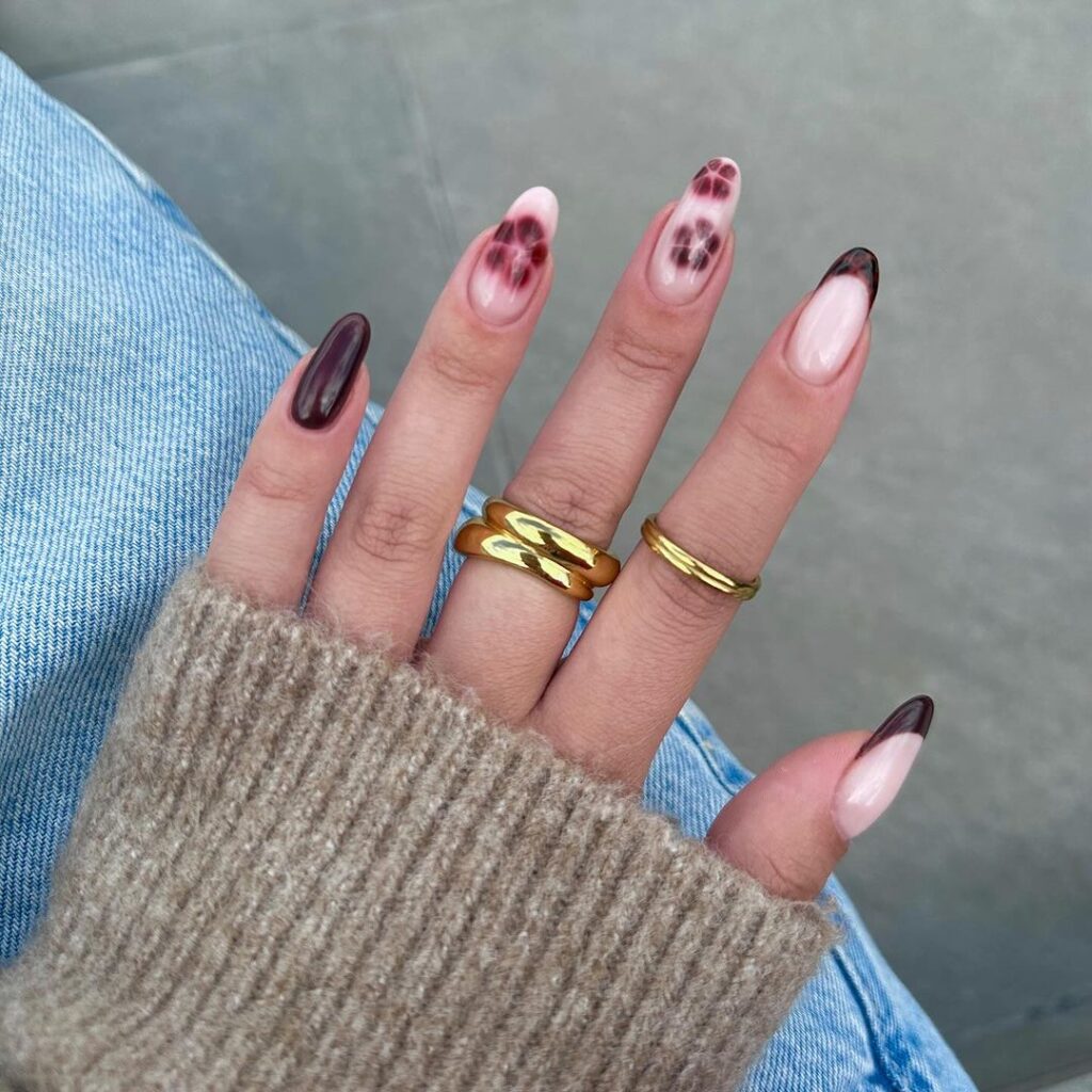 Autumn nail design with rich burgundy shades and soft plaid accents, combining neutral tones with detailed plaid for a cozy and playful look.