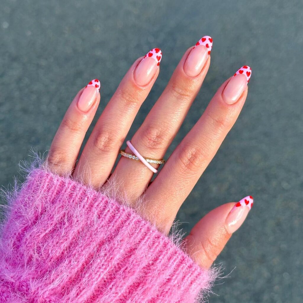 Sleek autumn nail design with a gradient of warm-toned neutrals, featuring a soft nude base and tiny red hearts for an elegant and romantic look.