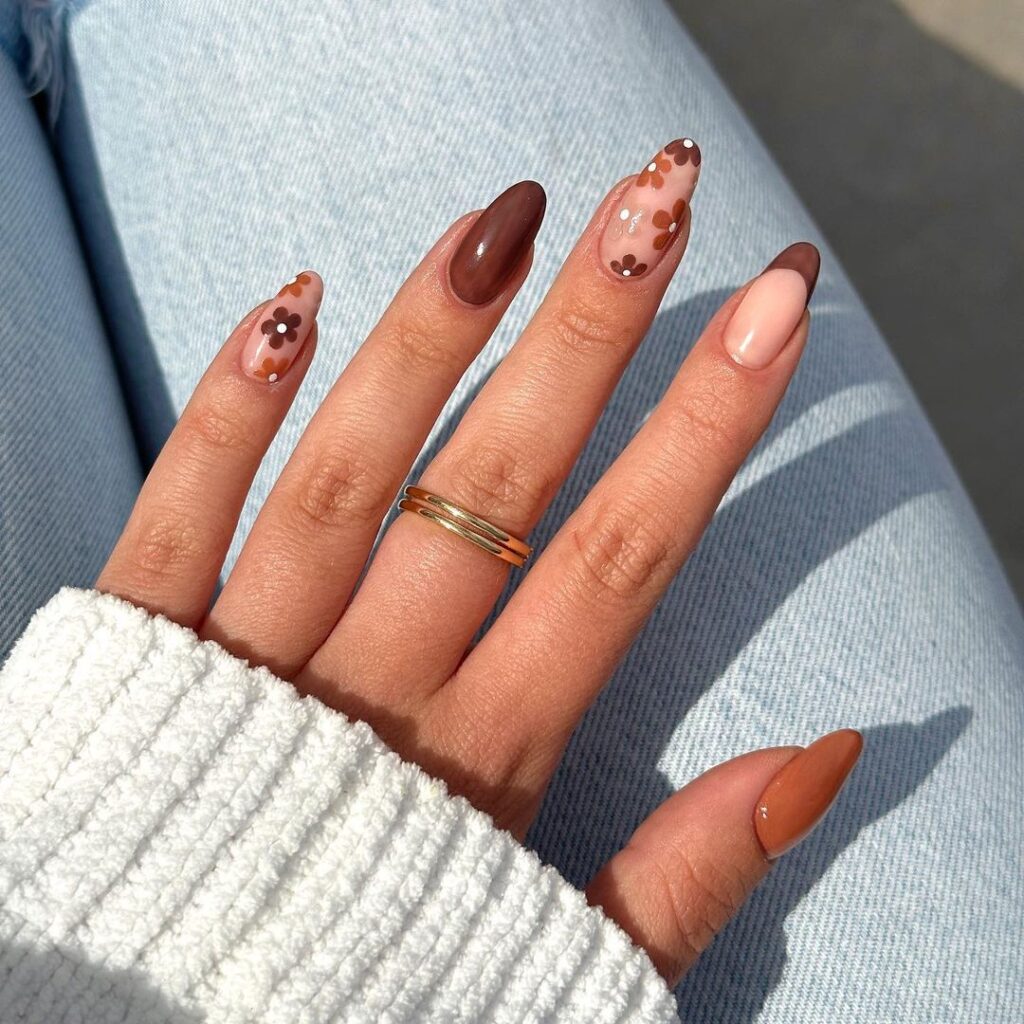 Fall nail design with warm browns and soft nudes, accented with delicate floral patterns, capturing the natural beauty of autumn.